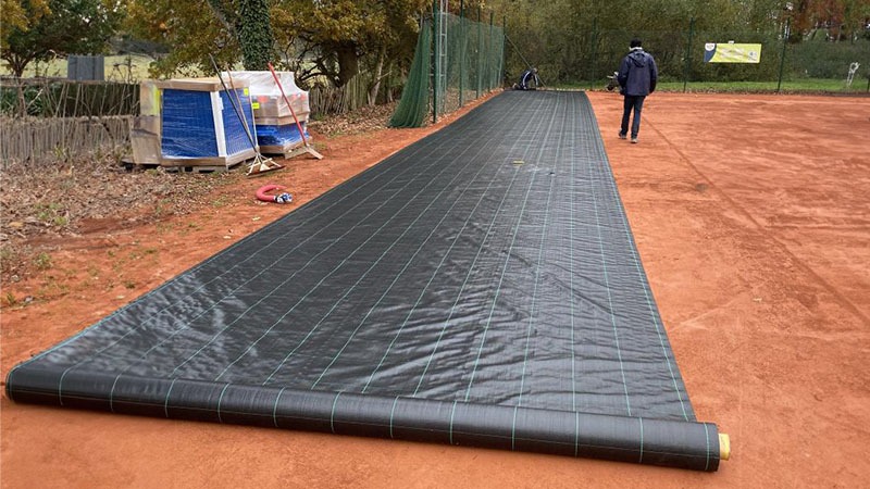 Flexter étape 2 : mise en œuvre de la sous-couche de protection sur un court en terre battue
