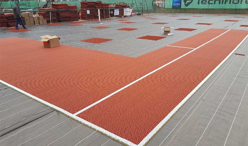 Image du revêtement modulaire en cours de pose et de la sous-couche de protection