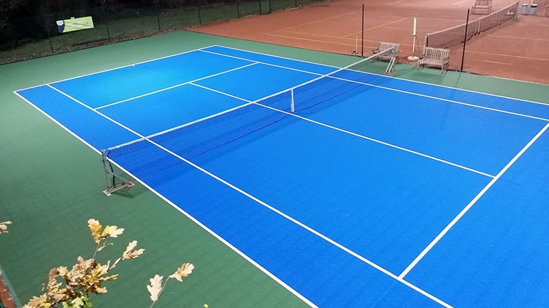 Image d'un court de tennis extérieur en terre battue transformé avec un revêtement modulaire