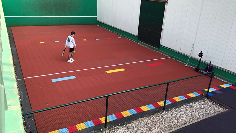 Image d'un revêtement modulaire installé au pied d'un mur d'entraînement
